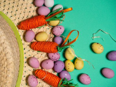 Yumurta ve çiçeklerle süslenmiş Paskalya şapkası. Yeşil arka plan. Yakın plan.