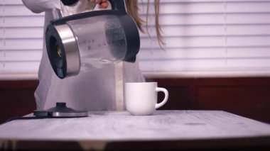 Çaydanlıktan bardağa sıcak su dökülüyor geniş çaplı zoom yavaş çekim seçici odaklanma