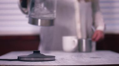 Çaydanlıktan bardağa sıcak su dökülüyor geniş çaplı zoom yavaş çekim seçici odaklanma