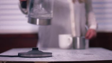 Çaydanlıktan kupaya sıcak su dökülüyor. 4 km yavaş çekim seçici odak noktası.