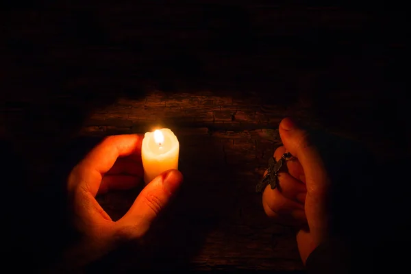 Crede l'uomo con una candela e un fuoco selettivo croce — Foto Stock