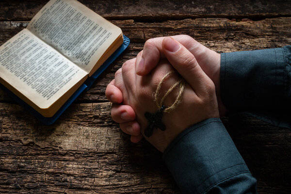 man praying before a bible selective focus