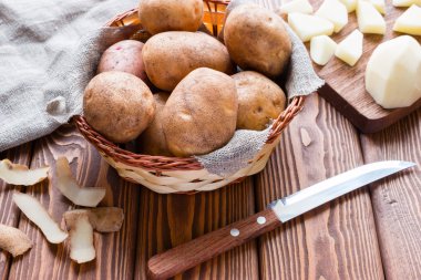 patates ve ahşap bir masa üzerinde bir bıçak ile sepeti