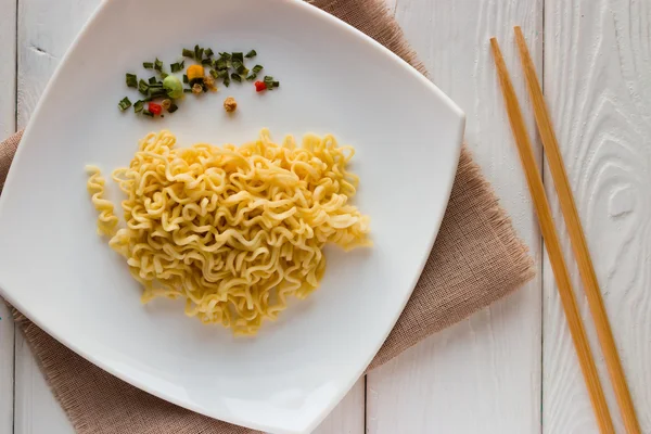 anlık erişte ve baharat plaka üzerinde ve beyaz bir arka plan üzerinde çubuk