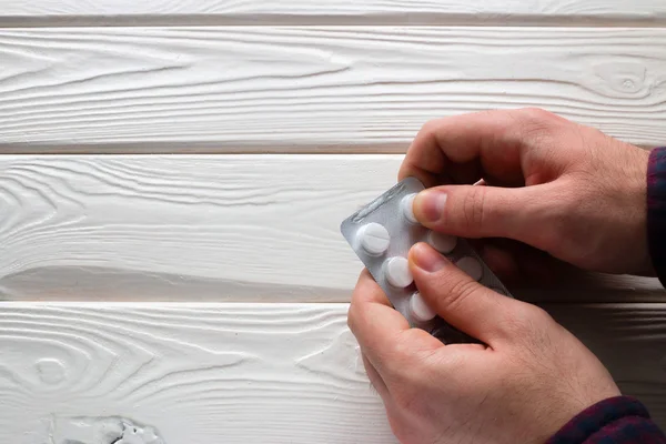 Hombre abre un paquete de pastillas — Foto de Stock