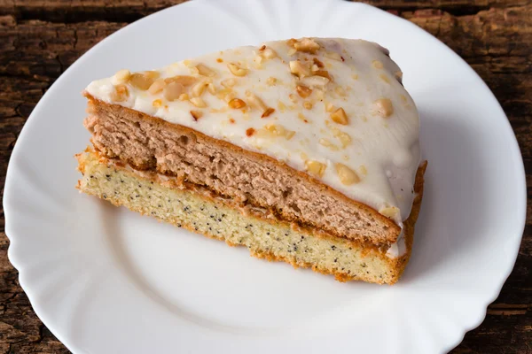 Торт на білій тарілці на дерев'яному фоні — стокове фото