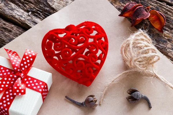 Gift box, röd sammet hjärtat på papper bland torra kronbladen — Stockfoto