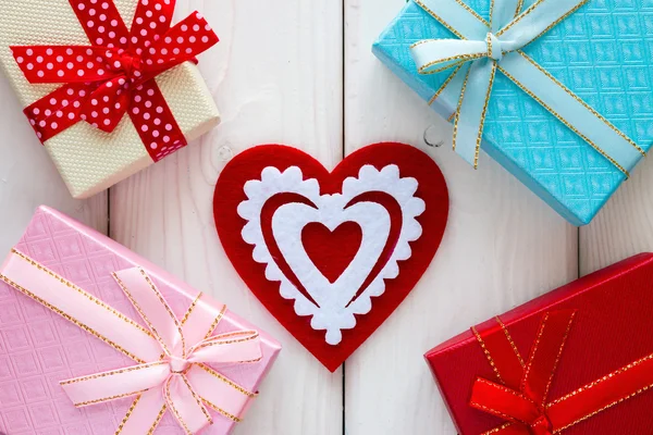 Bakgrunden på alla hjärtans dag röda hjärtat bredvid presentförpackning — Stockfoto