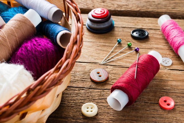 иголки и нитки рядом с корзиной
