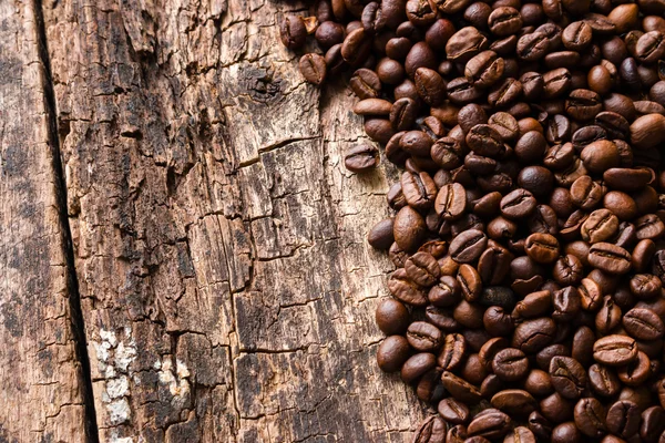 Rostade kaffebönor på toppen av en trä bakgrund Visa — Stockfoto