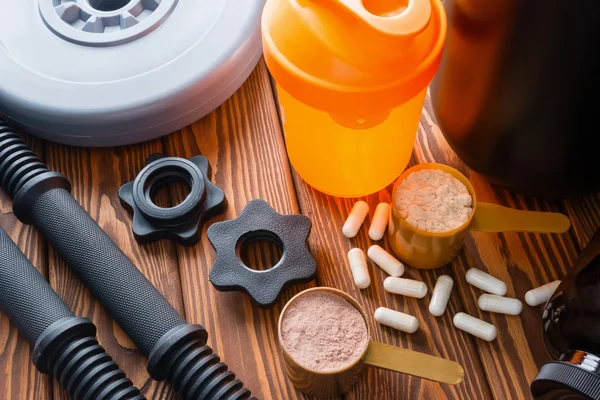 Shaker, boyun dambıl, protein ve amino asitler ahşap arka plan üzerinde