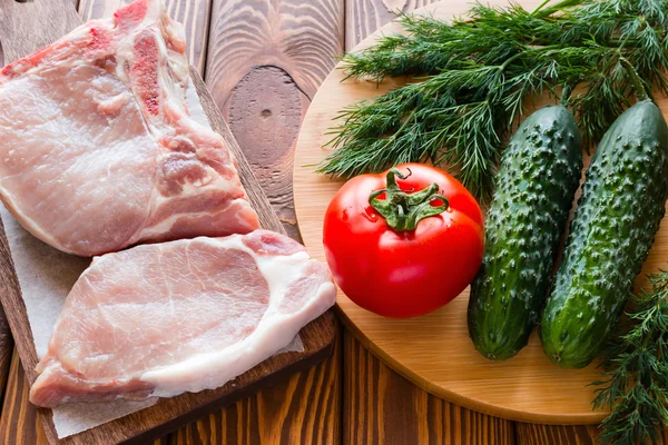 Daging mentah dan sayuran di papan potong — Stok Foto