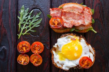Közlenmiş domates ve roka siyah bir arka plan ile lezzetli sandviçler yakın