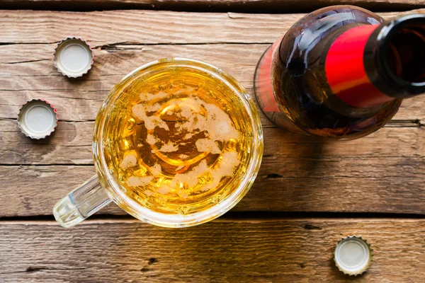 Bierkrug und Flasche auf hölzernem Hintergrund von oben — Stockfoto