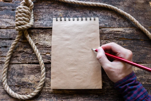 Man writes a suicide note in the notebook — Stock Photo, Image