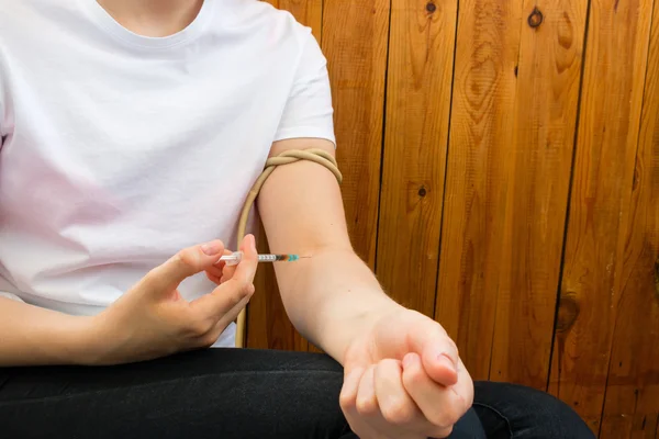 Mujer joven brazo vendado e inyecta drogas — Foto de Stock