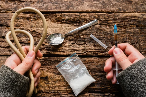 Viciado em drogas segurando seringa e torniquete — Fotografia de Stock