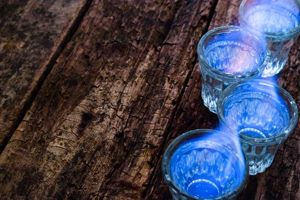 Burning vodka in a glass on a wooden background selective focus — Stock Photo, Image