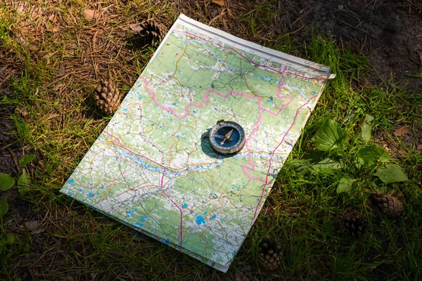 Mapa e bússola em um caminho na floresta — Fotografia de Stock