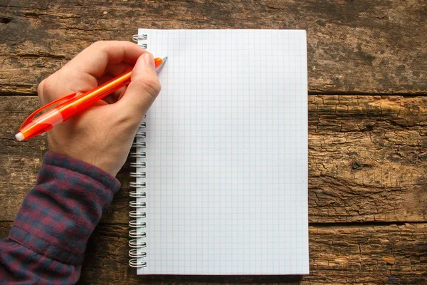 Left-handed man writes in a notebook — Stock Photo, Image