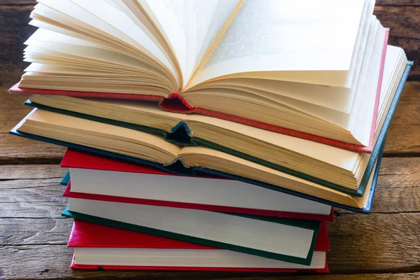 Pila di libri per imparare su uno sfondo di legno — Foto Stock