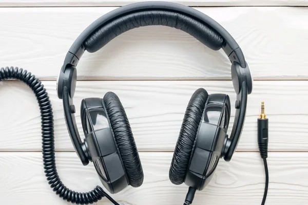 Auriculares negros de cerca sobre un fondo blanco — Foto de Stock