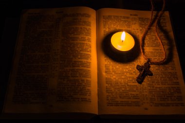 Yanan Mum ve bir çapraz İncil seçici odak üzerinde