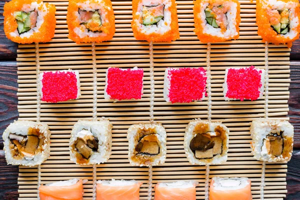 Sushi rullar av olika smaker på trä bakgrund — Stockfoto