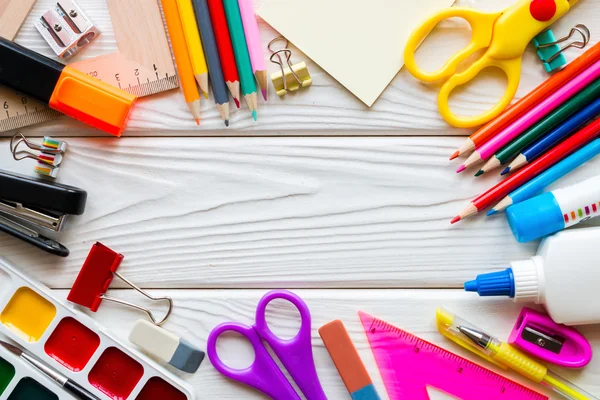 Plantilla de útiles escolares sobre un fondo de madera blanco — Foto de Stock