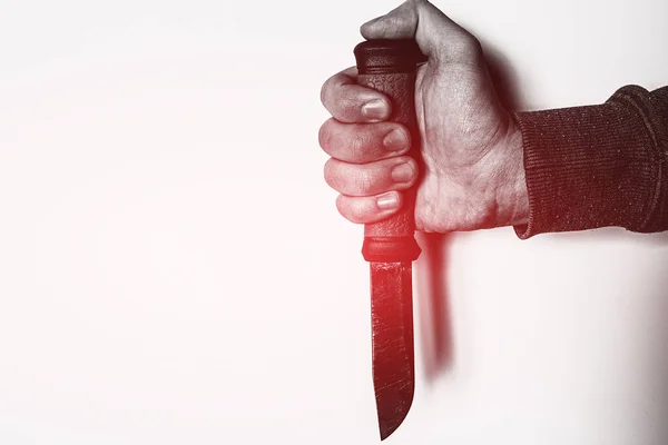 holding knife in hand with red glow crime concept on white background with place for text