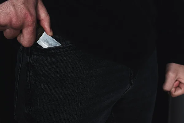 burglar killer criminal pulls out a knife from his pocket close-up