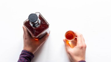 Elinde bir şişe ve elinde bir bardak alkol vardı.