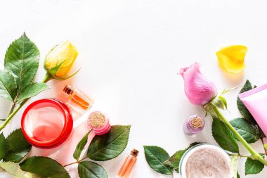 Beyaz arka plan şablonu üzerinde doğal kozmetik, spa kremleri ve çiçeklerden çerçeve