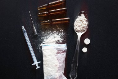 Uyuşturucu, hap, karanlık bir arka planda kaşıkta eroin.