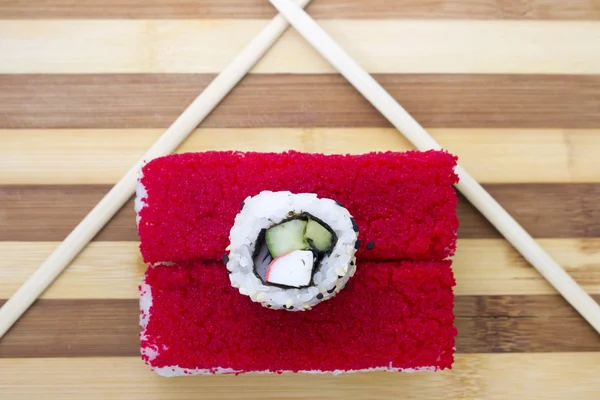Red rolls with chopsticks on a cutting board — Stock Photo, Image