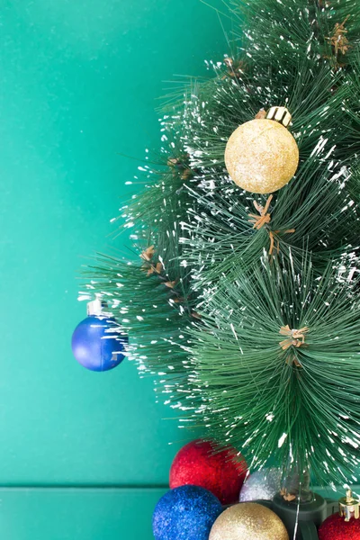 Metade da árvore de Natal e brinquedos em um fundo verde — Fotografia de Stock