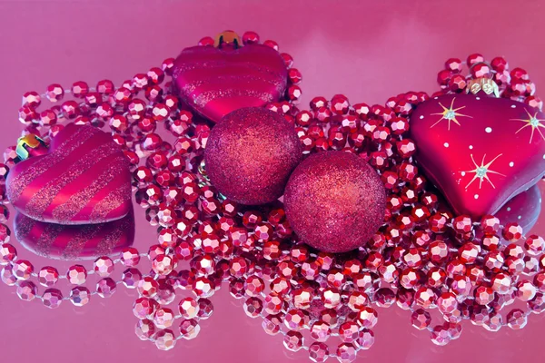 Juguetes de Navidad sobre un fondo rojo en el espejo — Foto de Stock