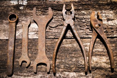Iron rusty tools working on an old wooden table