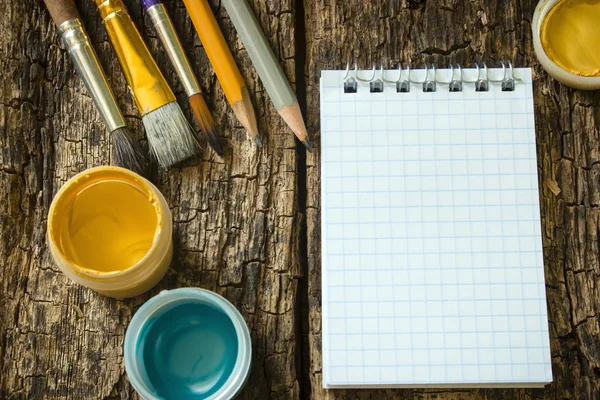 Brush painting, chiseled pencils, gouache paint, notepad on the old wooden table mock up — Zdjęcie stockowe