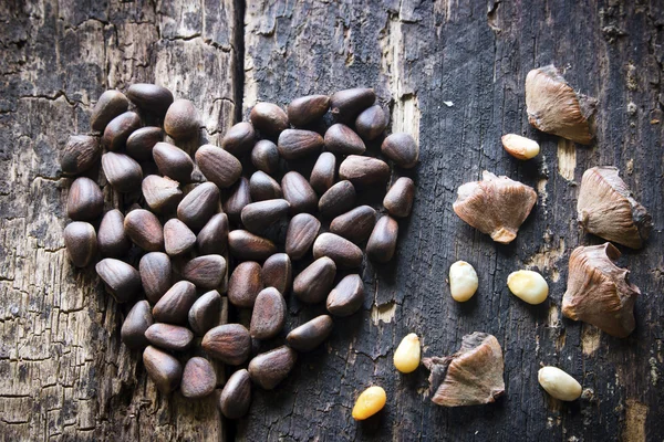 stock image the heart of the pine nuts and shells on the wooden table