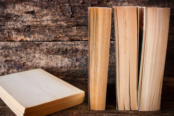 Libros viejos de pie en una fila al lado del libro en una mesa de madera —  Fotos de Stock