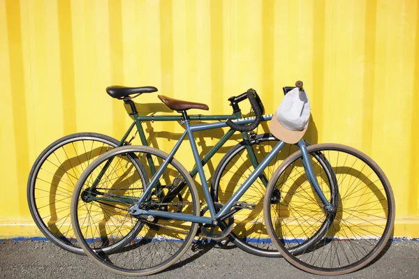 Sportfahrräder aufeinander auf gelbem Hintergrund — Stockfoto