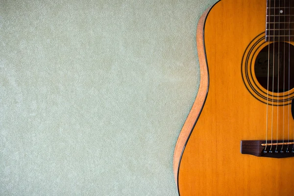 Yarısı boş bir arka plan üzerinde bir akustik gitar
