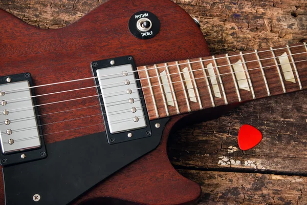 Guitarra eléctrica Les Paul con pico sobre fondo rojo de madera — Foto de Stock