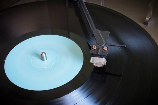 Roterande vinylskiva med blå etikett på en skivspelare närbild selektiv inriktning — Stockfoto