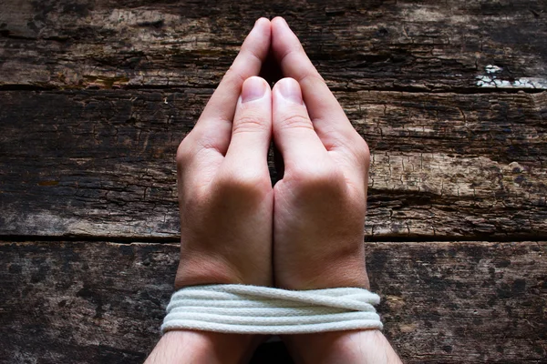 Uomo schiavo prega con le mani legate — Foto Stock