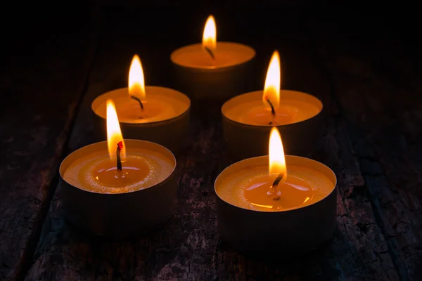 Scented candles burning on a black background — Stock Photo, Image