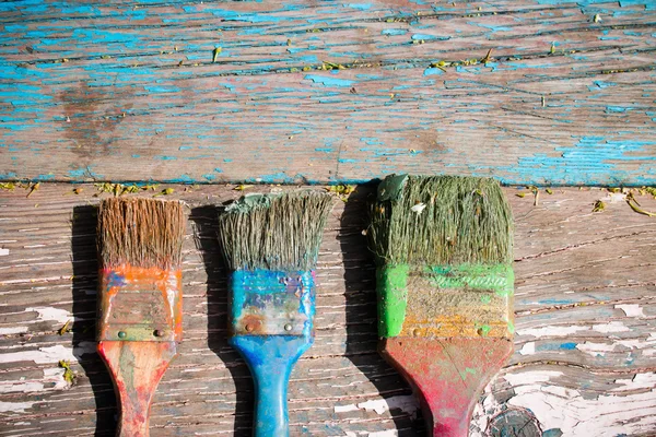 Viejo cepillo sucio para pintar sobre un fondo de madera — Foto de Stock