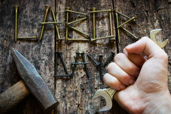 Człowiek posiadający klucza w ręku na tle napis dzień pracy selektywne focus — Zdjęcie stockowe