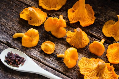Taze chanterelles ve baharat ahşap arka plan yan görünüm üzerinde kaşıkla